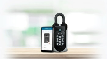 SentriGuard key safe next to a mobile phone with the Access+ app on-screen