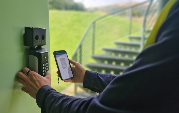 A man opening SentriGuard key safe with the app to retrieve keys for void property