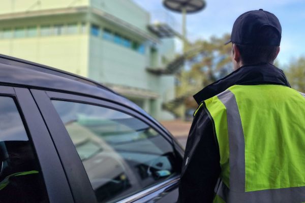 A security guard standing next to a vehicle responding to alarm callout